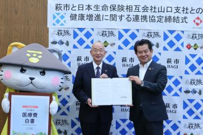 協定書への署名を終えた田中市長(左)と山本一浩支社長(右)